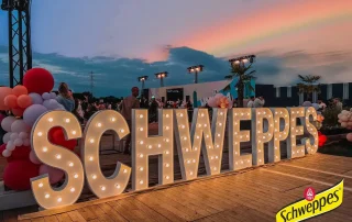 Lettres SCHWEPPES lumineuses, soirée en plein air Lettres SCHWEPPES lumineuses, soirée en plein air